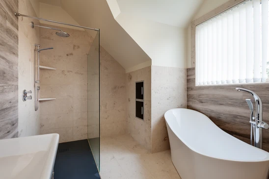 Salle de bain moderne sous combles avec douche à l'italienne et baignoire îlot