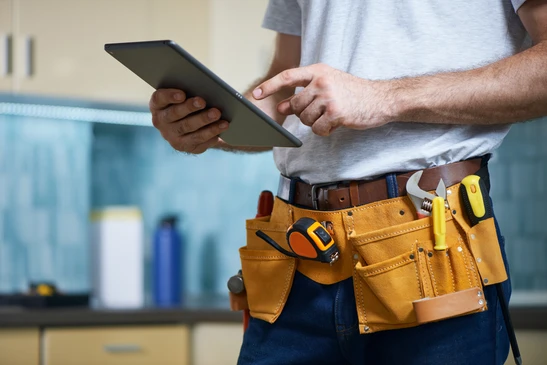 Scène d'atelier plomberie avec raccords flexibles et outils sur plans techniques